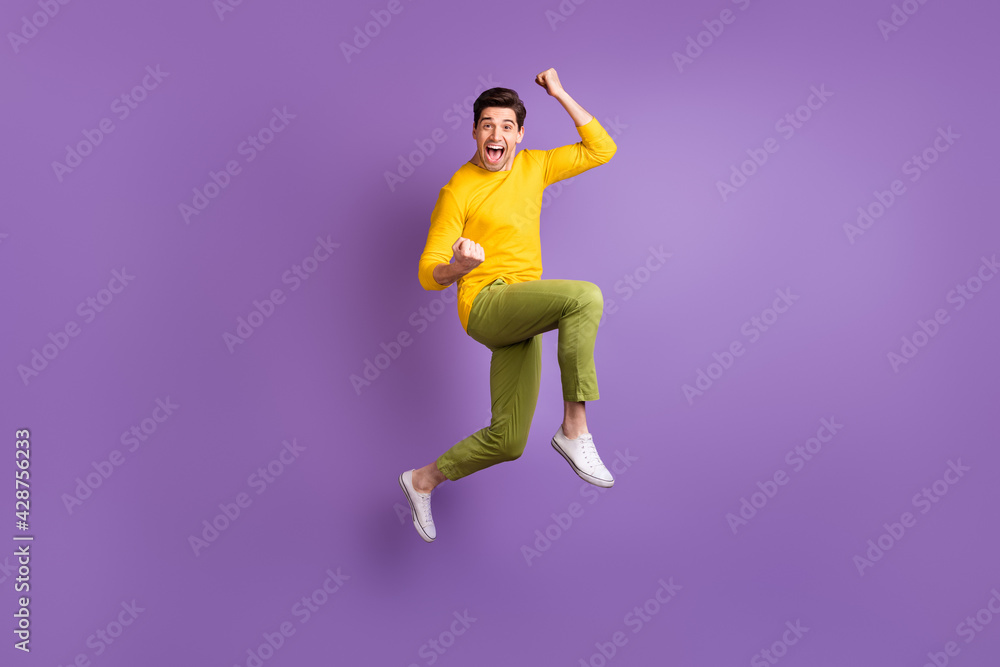 Full size photo of young happy excited crazy positive smiling man jumping in success victory isolated on violet color background