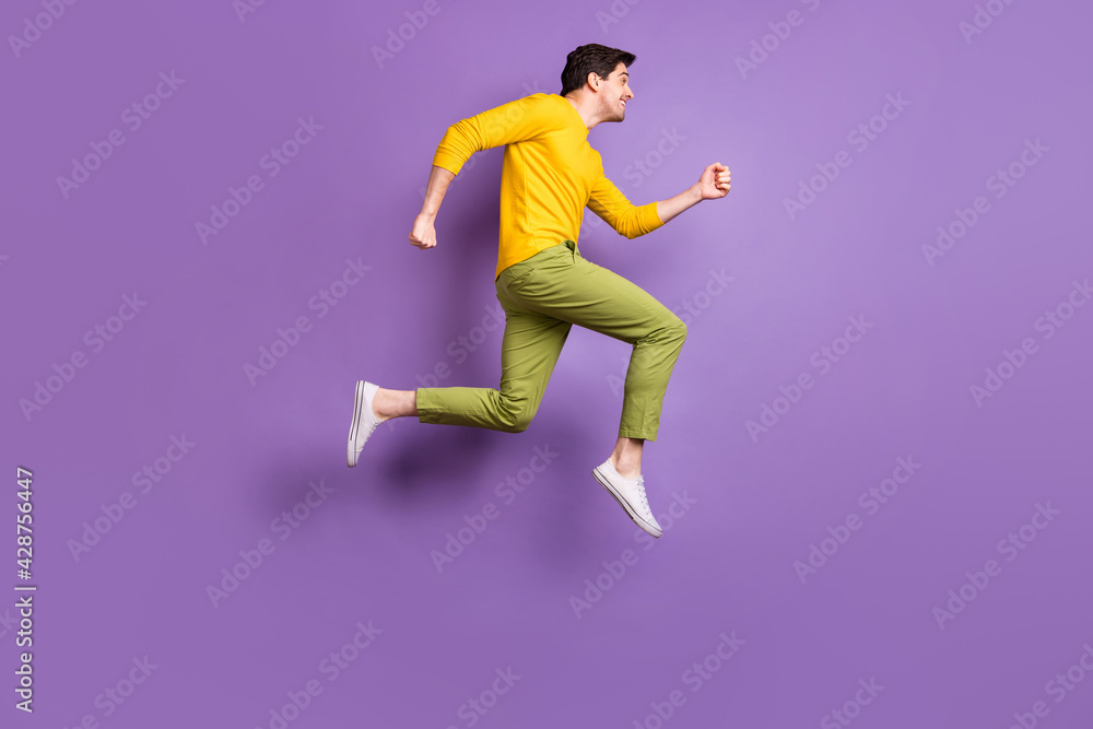 Full length profile side photo of young man happy positive smile jump go walk run hurry sale isolated over violet color background