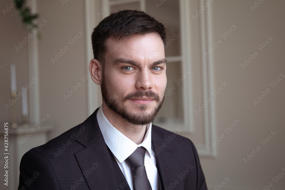 beautiful young man with a beard brunette model. guy in a classic suit in a light stylish interior. beautiful young man with a beard brunette model. guy in a classic suit in a light stylish interior.