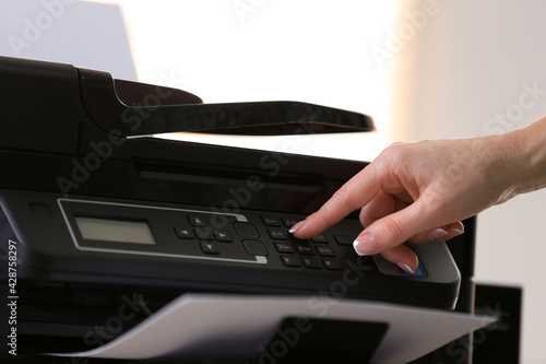 Woman using modern printer in office, closeup
