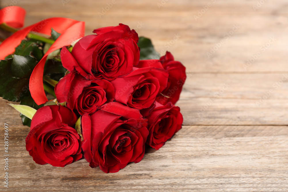 Beautiful red roses on wooden table, space for text. Valentine's Day celebration Beautiful red roses on wooden table, space for text. Valentine's Day celebration