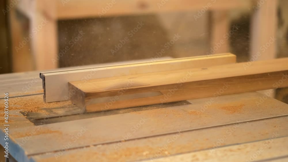 Disc saw in use releasing super fine sawdust from thermo pine plank. Thermowood in use. New wood material cut with disc saw. Disc saw in use releasing super fine sawdust from thermo pine plank. Thermowood in use. New wood material cut with disc saw.