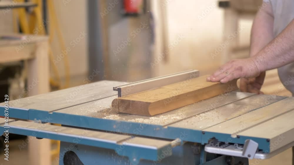 Carpenter working with disc saw without protection. Industrial machinery in wood construction site working on thermowood materials. Carpenter working with disc saw without protection. Industrial machinery in wood construction site working on thermowood materials.
