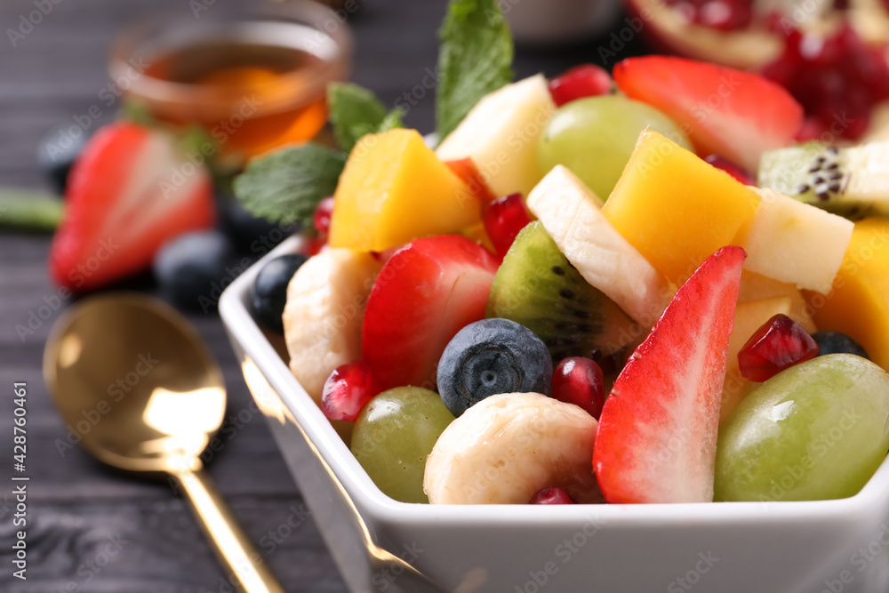 Delicious fresh fruit salad in bowl on table, closeup view Delicious fresh fruit salad in bowl on table, closeup view