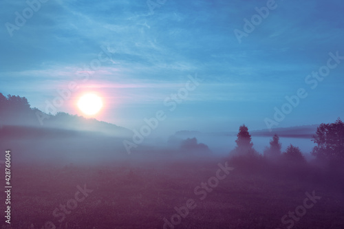 Sunrise over the meadow. Misty morning in the countryside