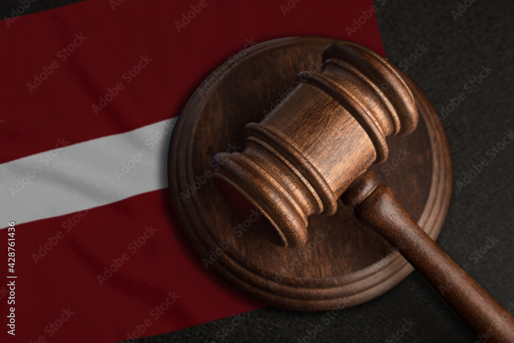 Judge gavel and flag of Latvia. Law and justice in Latvia. Violation of rights and freedoms