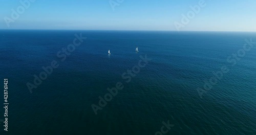 Aerial view of two sailboats sailing along the coast of Portimao, Algarve, Portugal