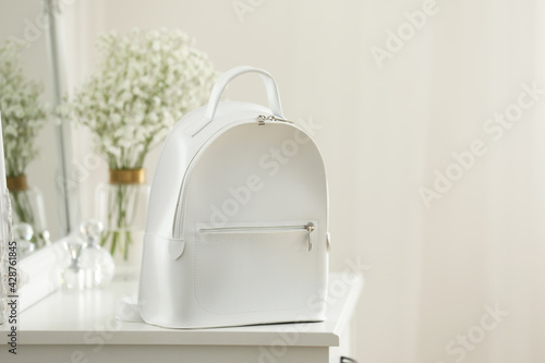 Stylish white backpack on table indoors, space for text