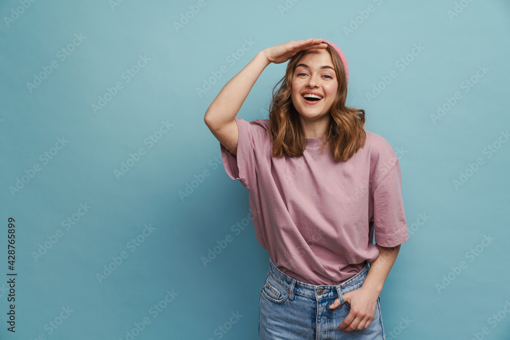Young happy woman smiling and looking at camera with hand at forehead Young happy woman smiling and looking at camera with hand at forehead