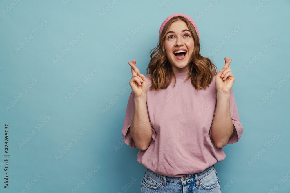 Young happy woman smiling and keeping fingers crossed Young happy woman smiling and keeping fingers crossed