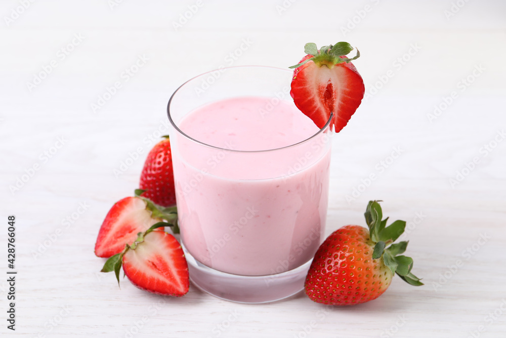 Delicious drink with strawberries on white table Delicious drink with strawberries on white table