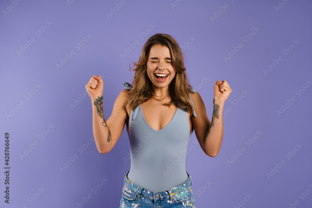 Young excited woman screaming while making winner gesture Young excited woman screaming while making winner gesture