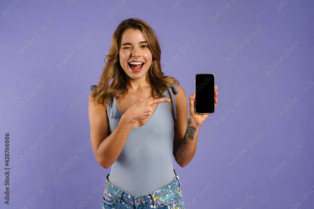 Young white woman smiling and pointing at cellphone Young white woman smiling and pointing at cellphone
