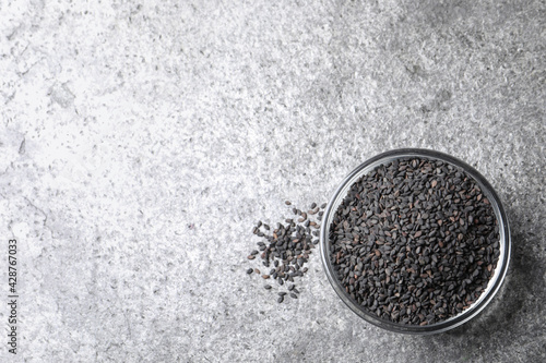 Black sesame seeds on grey table, flat lay. Space for text