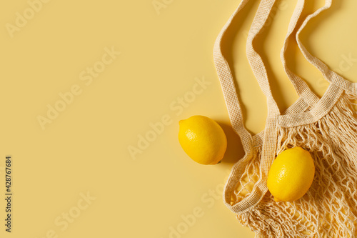 Zero waste concept with string bag, mesh bag, grosery bag with lemon on yellow background