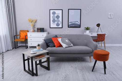 Stylish grey living room interior with comfortable sofa