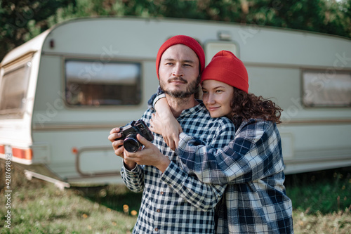 Romantic couple with a camera in nature near the trailer at home.