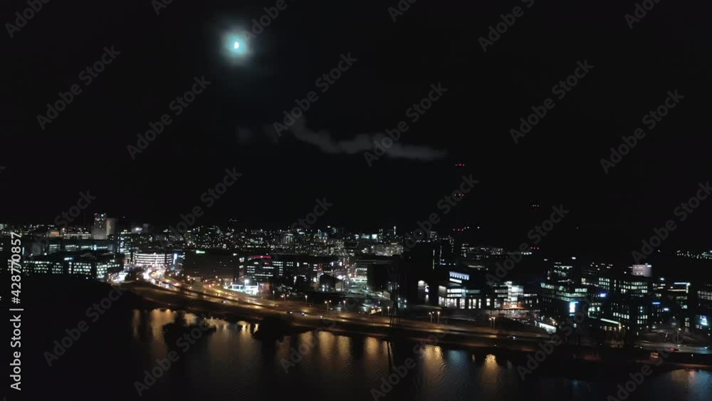 Helsinki.Finland-November 23. 2020: Awesome drone shot of a smoking chimney in Helsinki on a moonlit night. Aerial shot with the camera moving forward and sideways. Helsinki.Finland-November 23. 2020: Awesome drone shot of a smoking chimney in Helsinki on a moonlit night. Aerial shot with the camera moving forward and sideways.