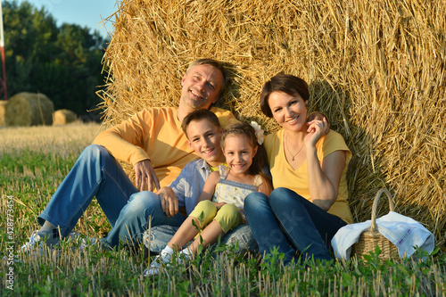Happy family on wheat field in sunny day
