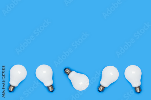 Bombillas de luz sobre un fondo azul liso y aislado. Vista superior. Copy space. Concepto: electricidad, energía photo