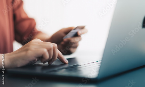 Hands holding plastic credit card and using laptop. Online shopping concept. soft focus