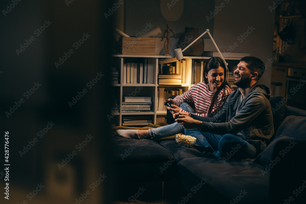 couple spending evening together at home. they are playing video games
