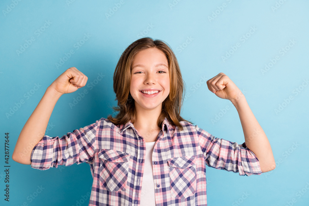 Photo of carefree friendly person arms flexing biceps toothy smile wear plaid isolated on blue color background Photo of carefree friendly person arms flexing biceps toothy smile wear plaid isolated on blue color background