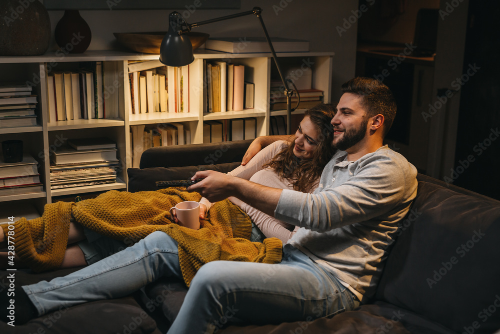Obraz premium couple watching television together at home. evening scene