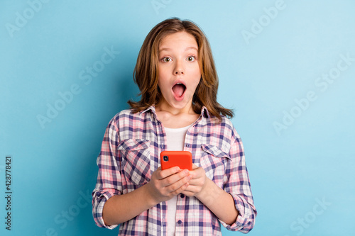 Photo of impressed pupil arms hold device open mouth staring camera isolated on blue color background