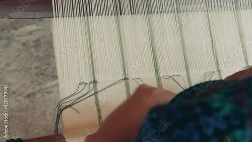 Mayan Woman Weaving Traditional Textiles On A Backstrap Loom In Guatemala, Central America - high angle, close up photo