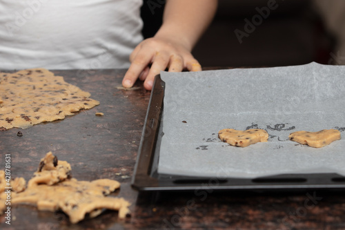 Kids baking cookies in house kitchen . Close up child hands preparing cookies using cookie.