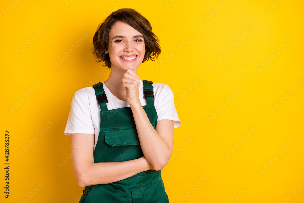 Photo of optimistic nice brown hair lady hand chin wear uniform isolated on yellow background Photo of optimistic nice brown hair lady hand chin wear uniform isolated on yellow background