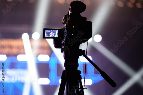TV camera in a concert hall with laser lighting. Professional digital video camera.
