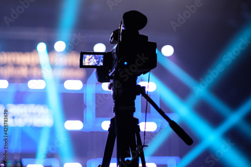 TV camera in a concert hall with laser lighting. Professional digital video camera.