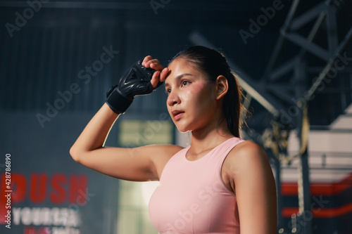 Portrait young happy beauty Asian sport woman sportswear and relaxing adjusting the gloves getting ready for exercise training. well bing lifestyle, sport and gym concept.