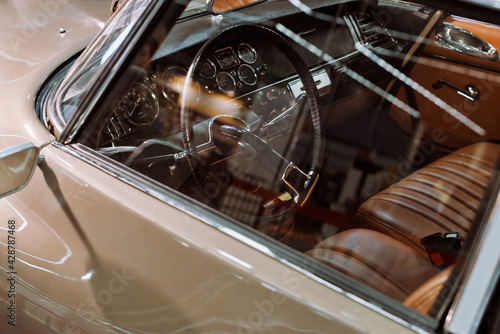 Interior of a beige classic car with leather seats at a car show or exhibition
