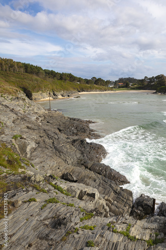 Vertical shot of the rocky shore in Valdovino, Galicia, Spain photo