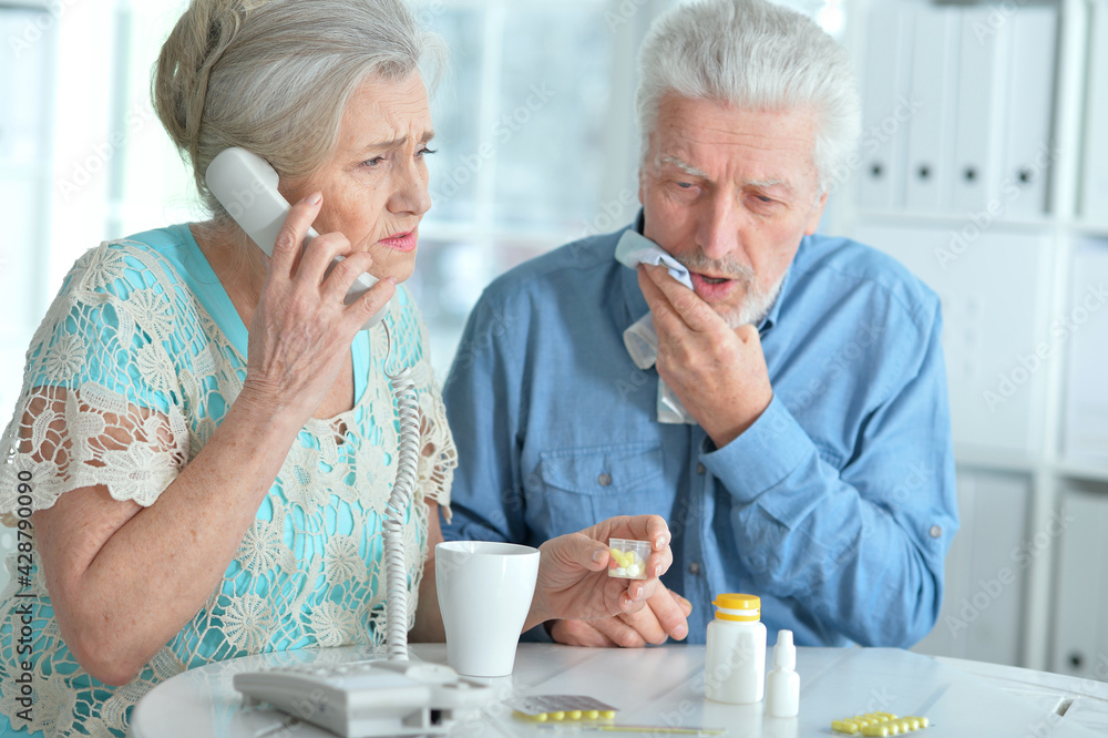 Sick senior couple calling to doctor Sick senior couple calling to doctor