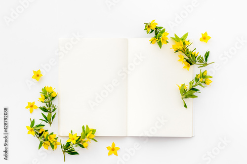 White paper mock up with yellow flowers, view from above