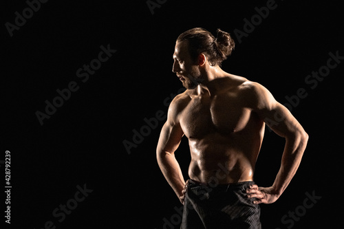 Portrait of athletic man on black background © a_medvedkov