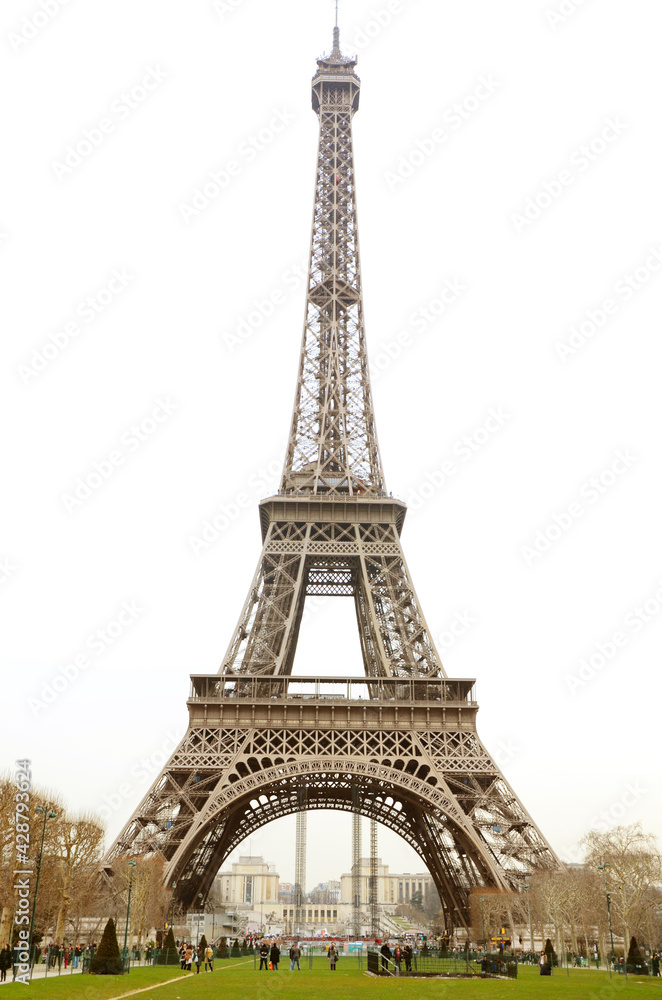 Tourist gathering under Tour de Eiffel on a cloudy day.