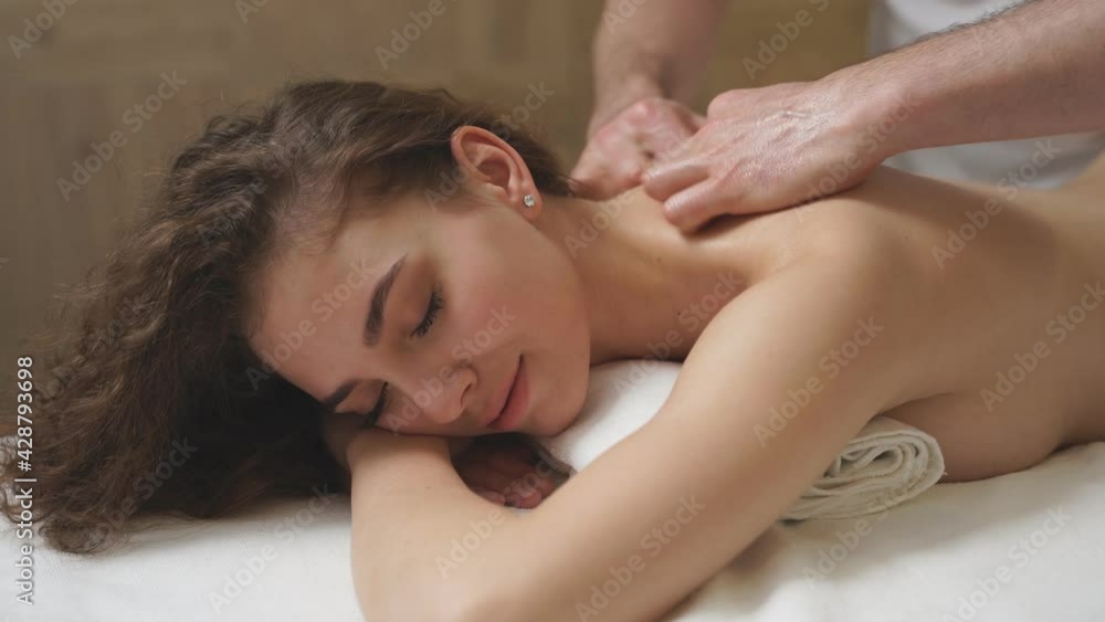 Calm young caucasian woman receiving full body massage at modern spa. Calm young caucasian woman receiving full body massage at modern spa.