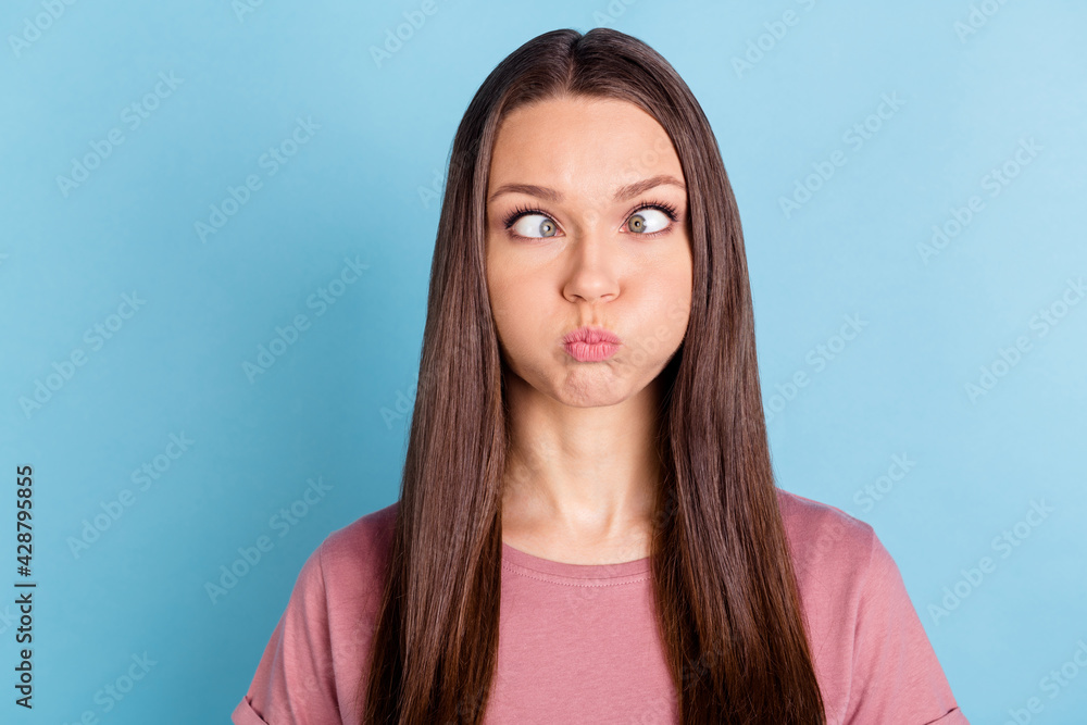 Photo of funky cheerful young woman make funny face hold air cheek isolated on blue color background Photo of funky cheerful young woman make funny face hold air cheek isolated on blue color background