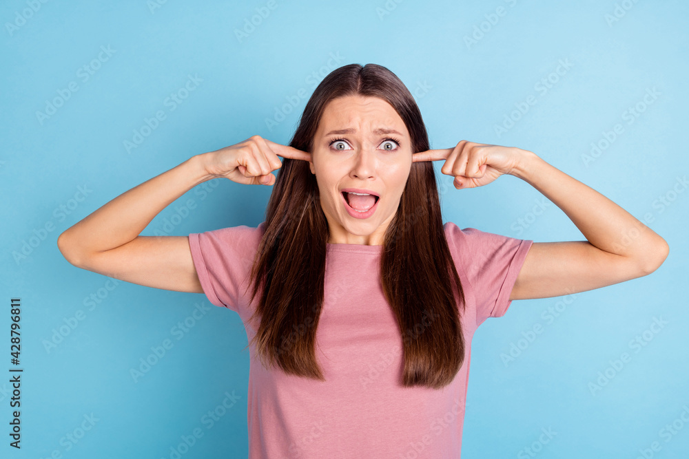 Photo of scared unhappy upset young woman cover ears fingers loud noise isolated on pastel blue color background