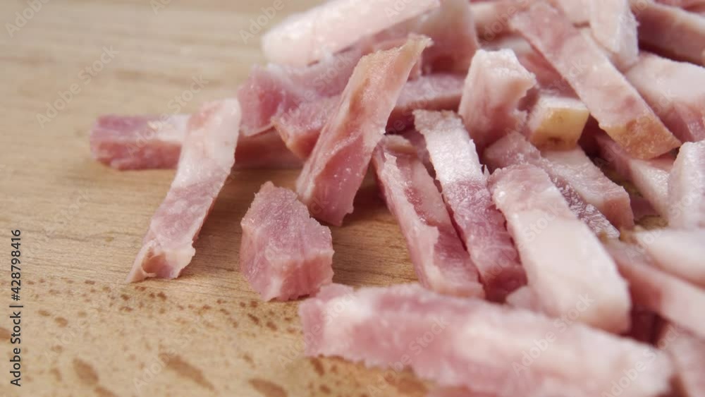 Meat delicacy. Sliced bacon cubes on a wooden cutting board. Macro. Dolly Shot Meat delicacy. Sliced bacon cubes on a wooden cutting board. Macro. Dolly Shot