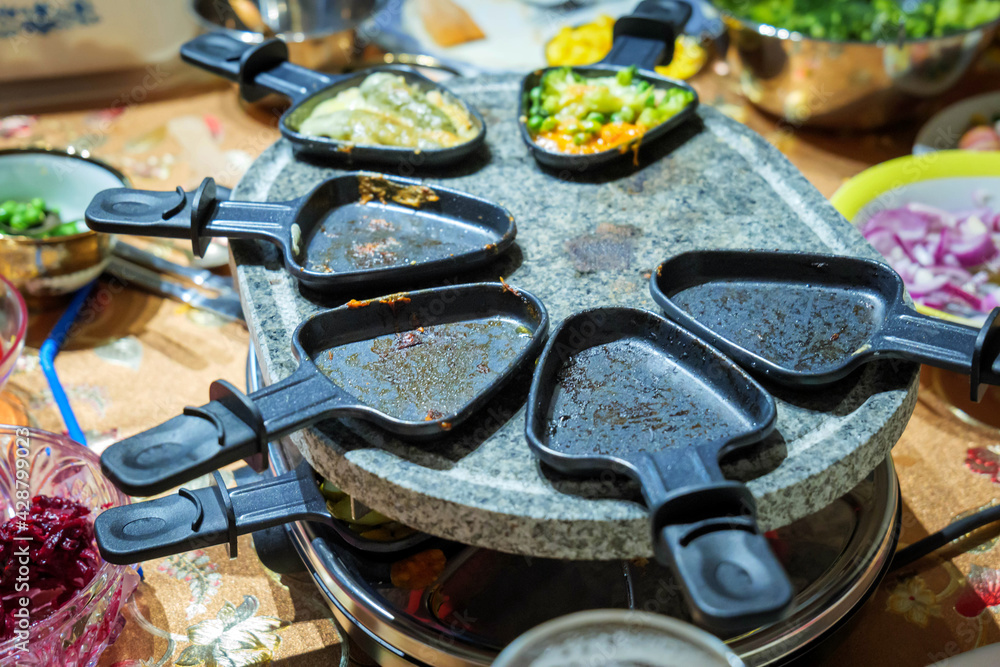 family dinner table share food on raclette