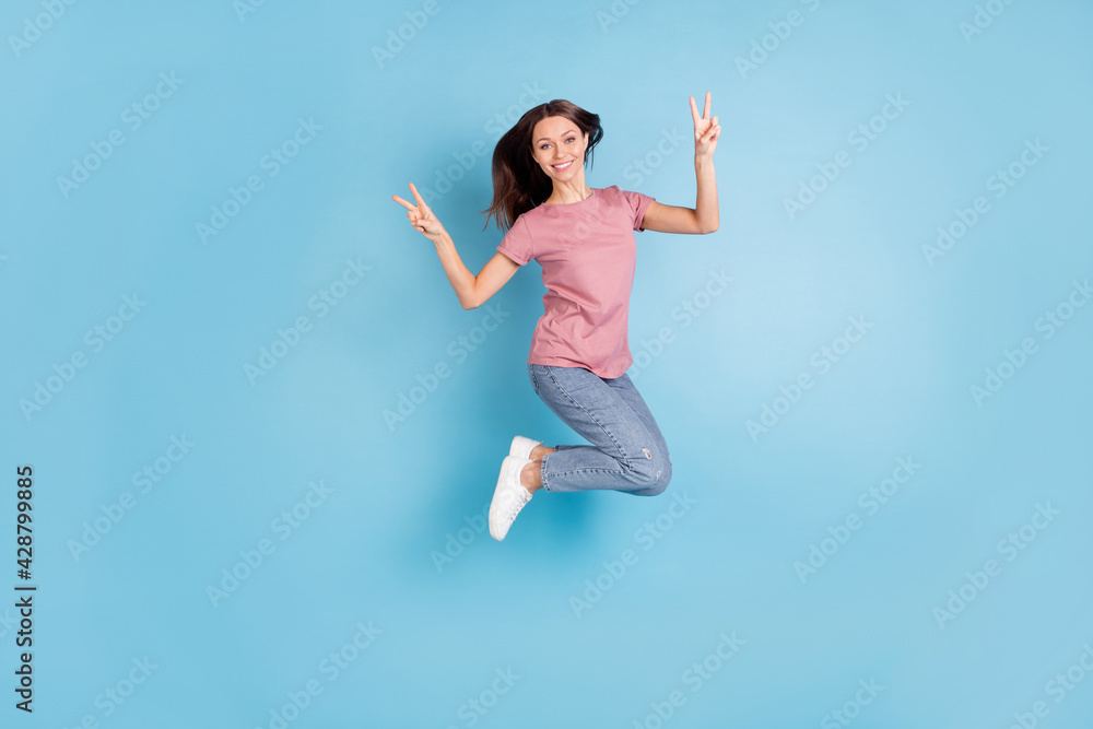 Full length profile side photo of cheerful cool girl jump up make v-signs isolated on pastel blue color background