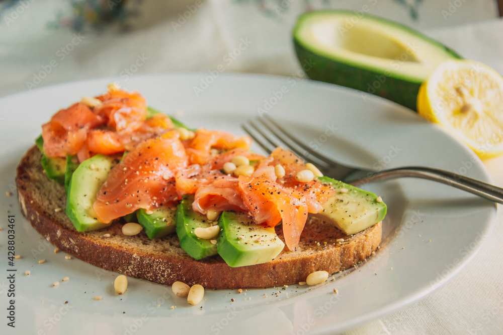 Healthy avocado toast with rye bread, sliced avocado,salmon,seeds, salt and pepper. Vegetarian food. Clean eating. Healthy avocado toast with rye bread, sliced avocado,salmon,seeds, salt and pepper. Vegetarian food. Clean eating.