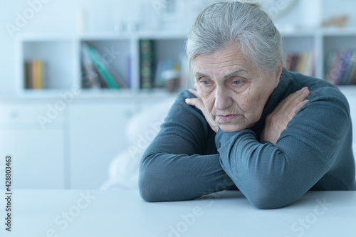  sad senior woman sitting at table