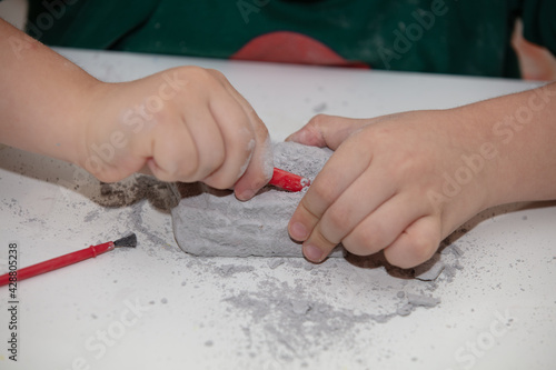 children's entertainment, a child plays in an archaeologist, children's hands dig dinosaur bones